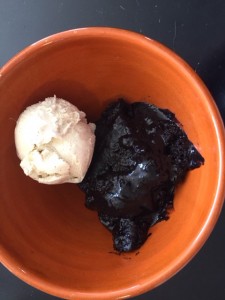 molten chocolate cake and vanilla ice cream in an orange bowl.