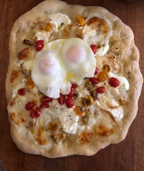 Dorothy's pizza with cherry tomatoes, fresh mozzarella, ricotta, leeks, fresh garlic, topped with 2 fried eggs.