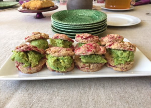 Platter containing raspberry biscuits with avocado filling.