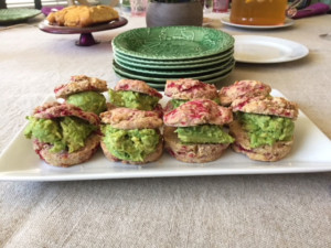 Platter containing raspberry biscuits with avocado filling.